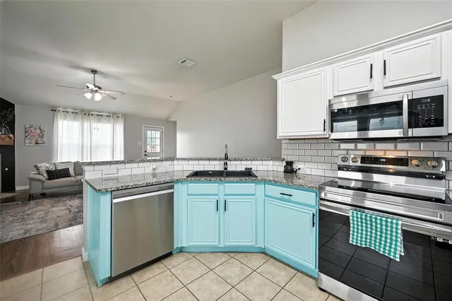 a kitchen with stainless steel appliances granite countertop a sink and cabinets