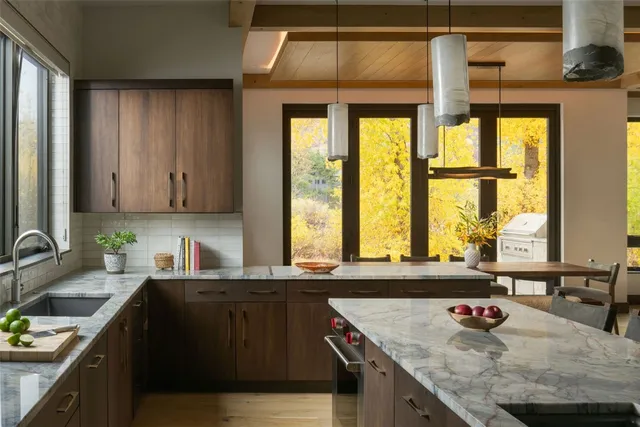 a kitchen with stainless steel appliances granite countertop a sink window and cabinets