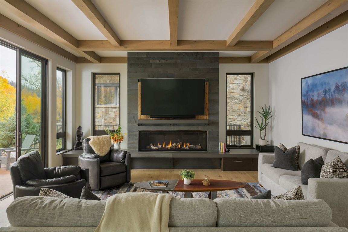 321 Riverview Way Steamboat Springs, CO 80487 - Photo 10 of 50 a living room with furniture a large window and a fireplace