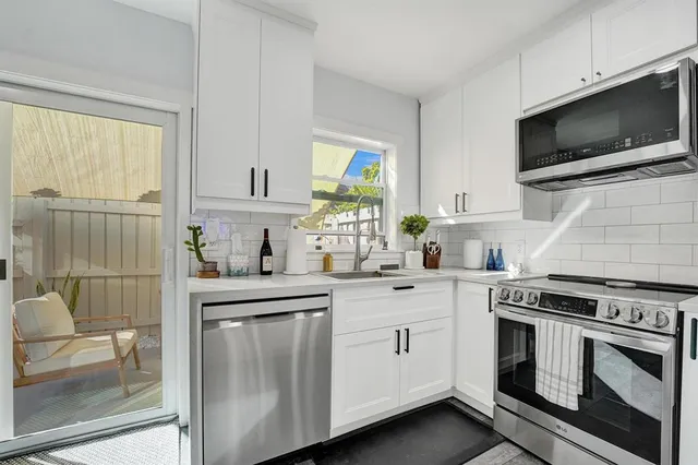 a kitchen with cabinets stainless steel appliances and a window
