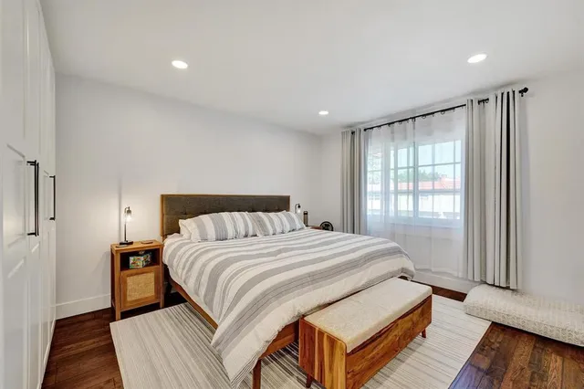a spacious bedroom with a bed and wooden floor