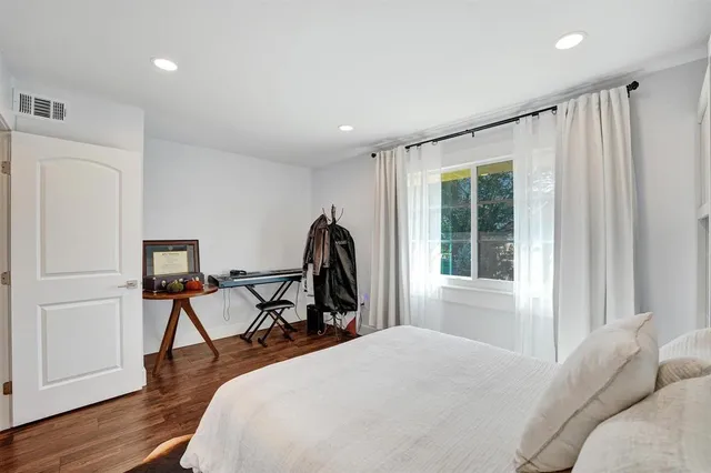 a bedroom with a bed and wooden floor