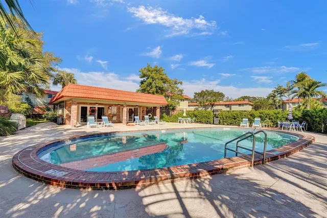 swimming pool view with a seating space and a garden view