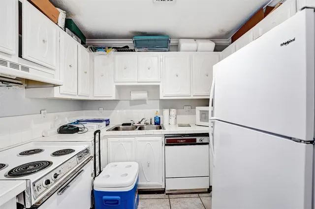a kitchen with stainless steel appliances a refrigerator a sink a stove and white cabinets