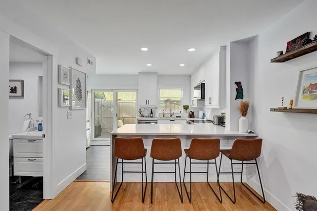 a kitchen with cabinets and chairs