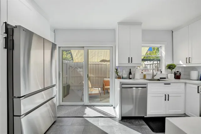 a kitchen with white cabinets and refrigerator