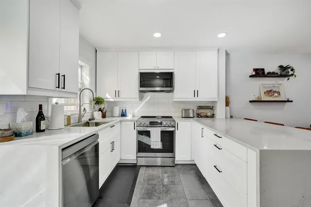 a kitchen with granite countertop a stove top oven sink and cabinets