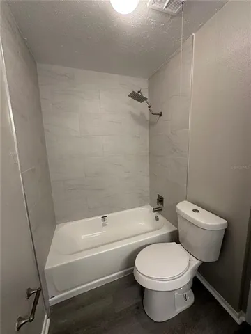 a bathroom with a toilet and a bath tub