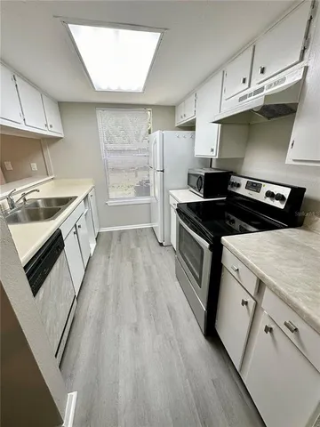 a kitchen with a stove top oven and cabinets