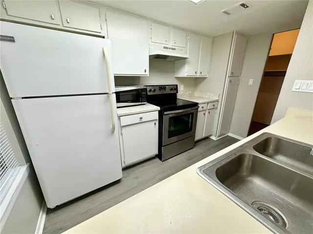 a kitchen with a refrigerator sink and stove