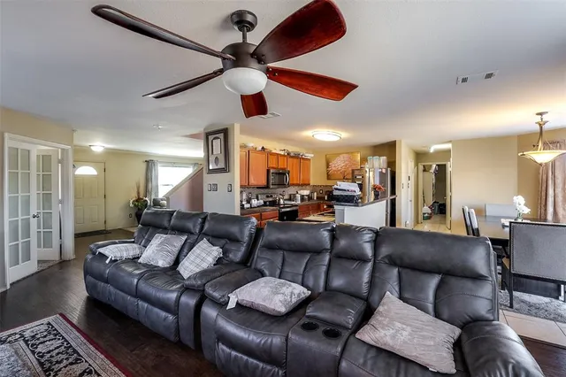 a living room with furniture kitchen view and a chandelier