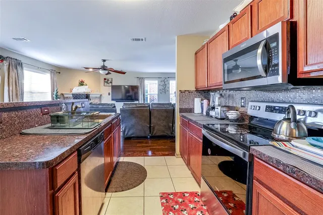 a kitchen with stainless steel appliances granite countertop a stove a sink and a microwave