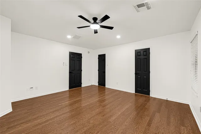 a view of an empty room with wooden floor