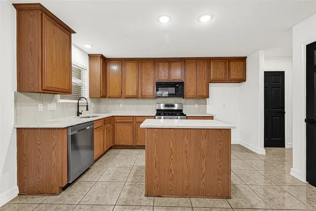 a kitchen with stainless steel appliances granite countertop a sink stove and microwave