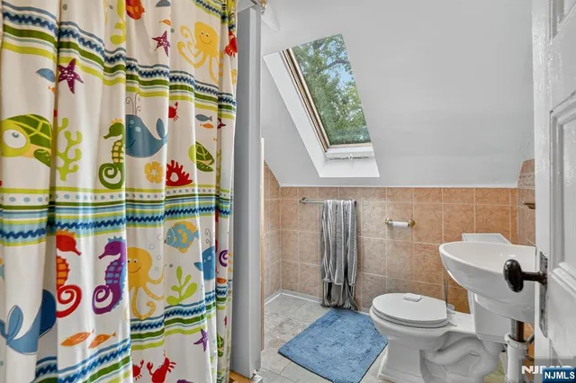 a bathroom with a toilet and a shower curtain