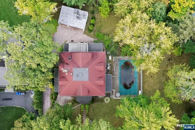 an aerial view of a house with a yard and tree s