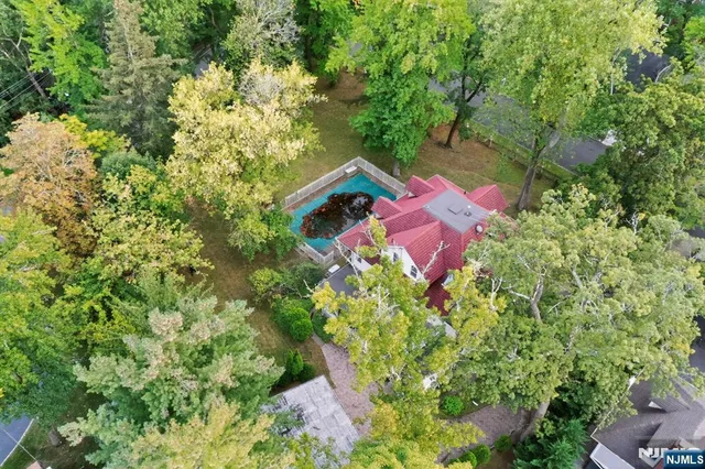 an aerial view of a house with a yard and swimming pool