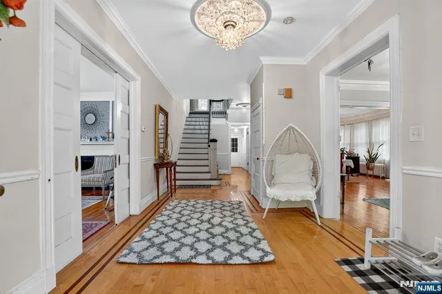 a room with lots of white furniture and wooden floor