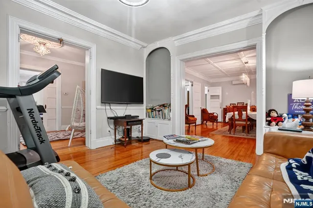 a living room with furniture a flat screen tv and a floor to ceiling window