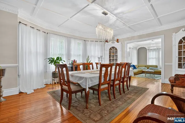 a view of a a dining room with furniture window and wooden floor
