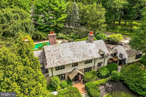 an aerial view of a house with a yard and large trees