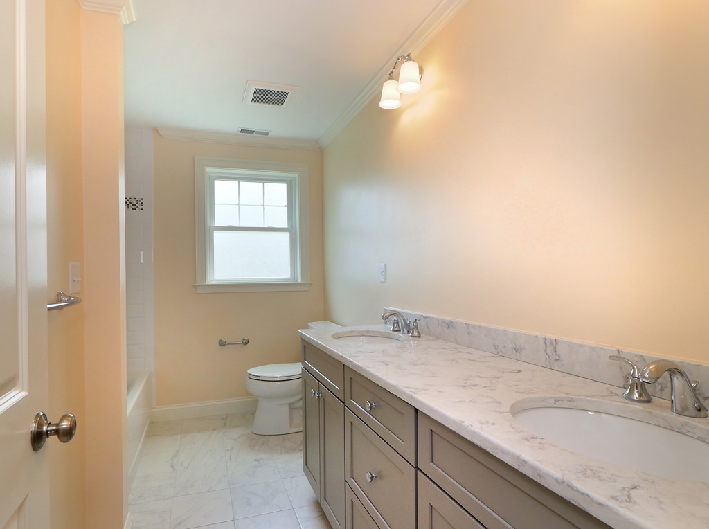 6 Tower Road Arlington, MA 02474 - Photo 22 of 30 a bathroom with a granite countertop sink a toilet and a mirror