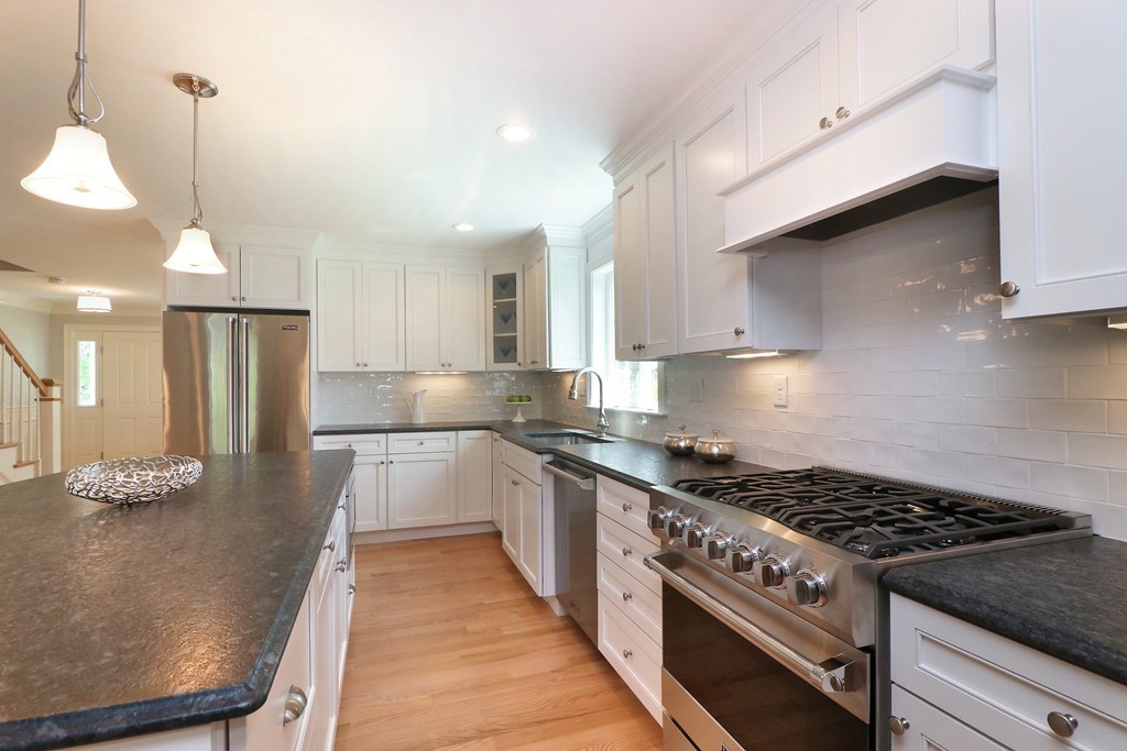6 Tower Road Arlington, MA 02474 - Photo 8 of 30 a kitchen with stainless steel appliances kitchen island granite countertop a stove a sink and a refrigerator