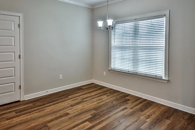 a view of a room with wooden floor and a window