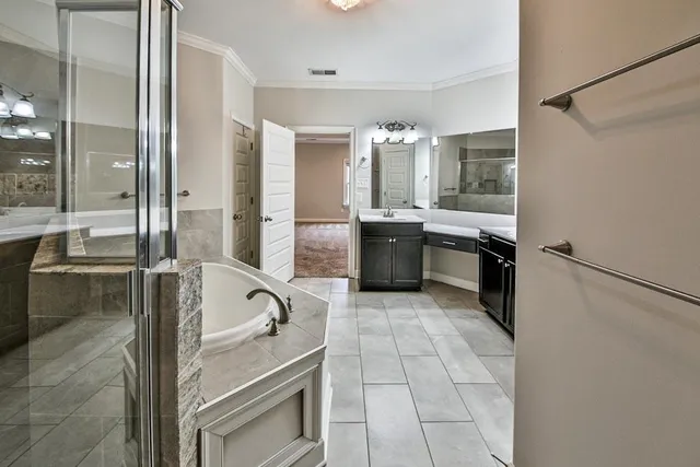 a large bathroom with a tub a sink and glass door