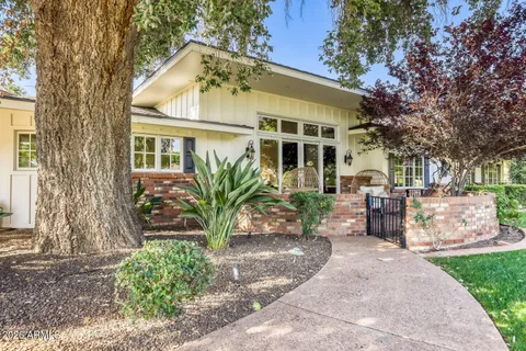a view of a house with a big yard plants and large trees