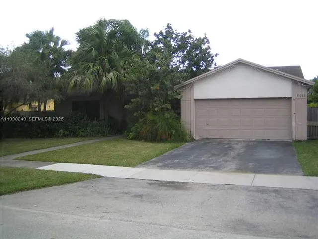 a view of backyard of house and car parked