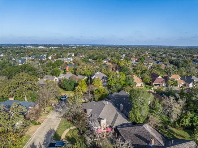 an aerial view of residential houses with outdoor space and trees