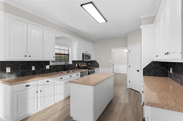 a kitchen with white cabinets and sink