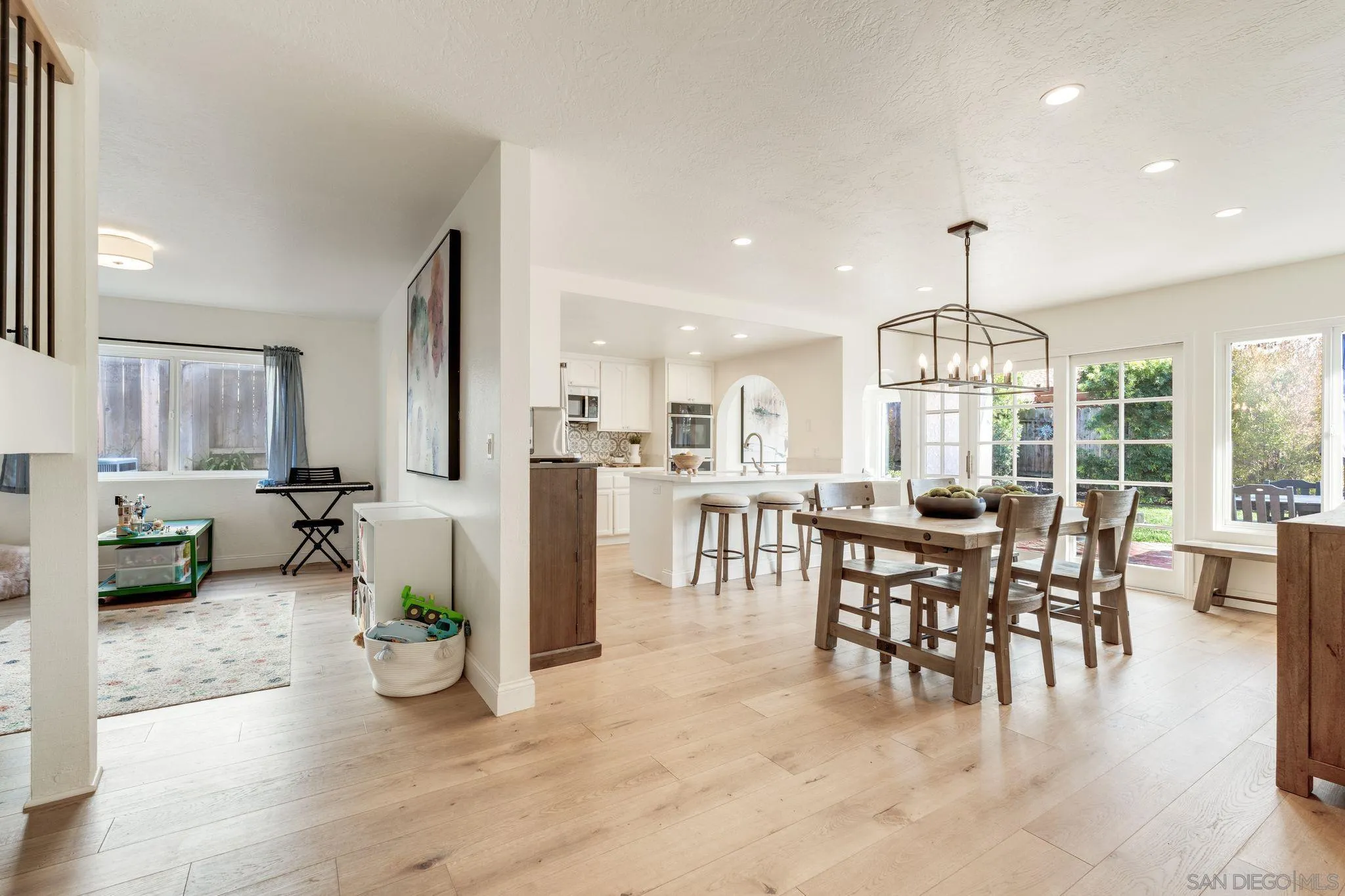 135 Little Oaks Road Encinitas, CA 92024 - Photo 17 of 59 a view of a dining room and livingroom with furniture wooden floor a chandelier