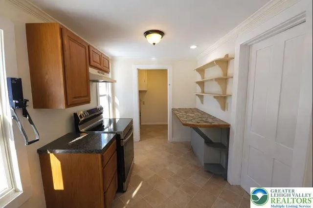 a kitchen with stainless steel appliances granite countertop a refrigerator and a stove top oven