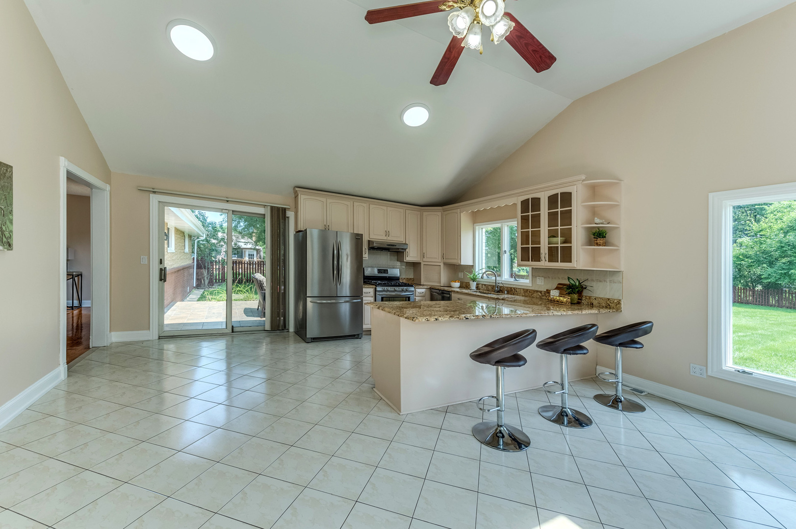 105 North Wolf Road Prospect Heights, IL 60070 - Photo 13 of 26 a kitchen with stainless steel appliances kitchen island granite countertop a refrigerator a stove a microwave oven with white cabinets and couches