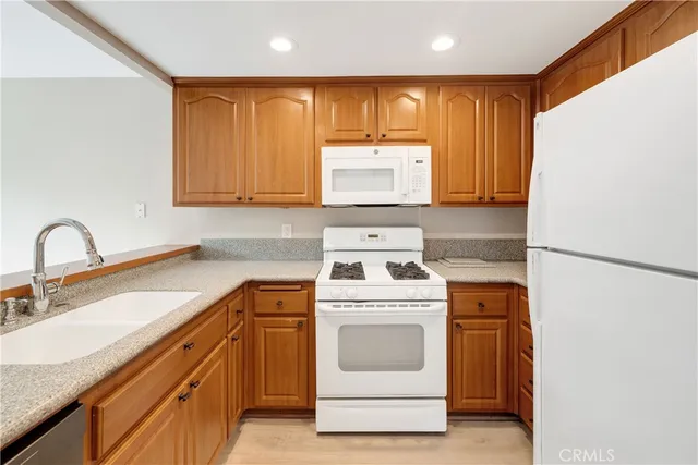 a kitchen with stainless steel appliances granite countertop a refrigerator sink stove and microwave