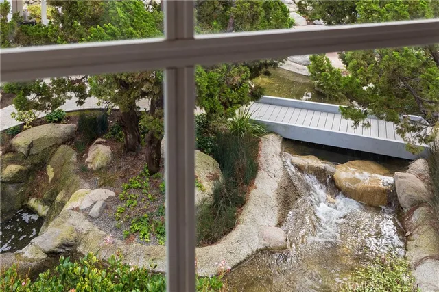 a view of swimming pool with lawn chairs and plants