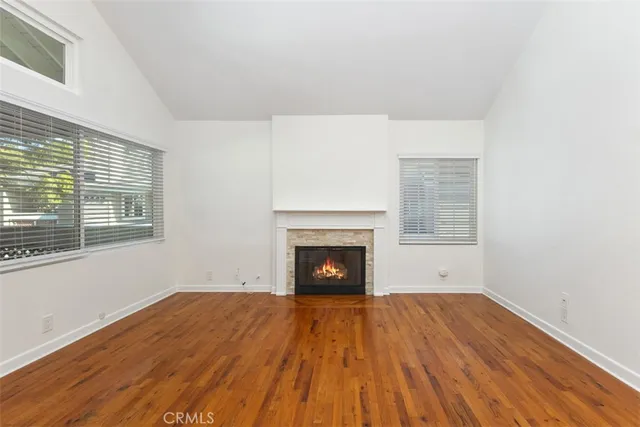 a view of empty room with wooden floor and fireplace