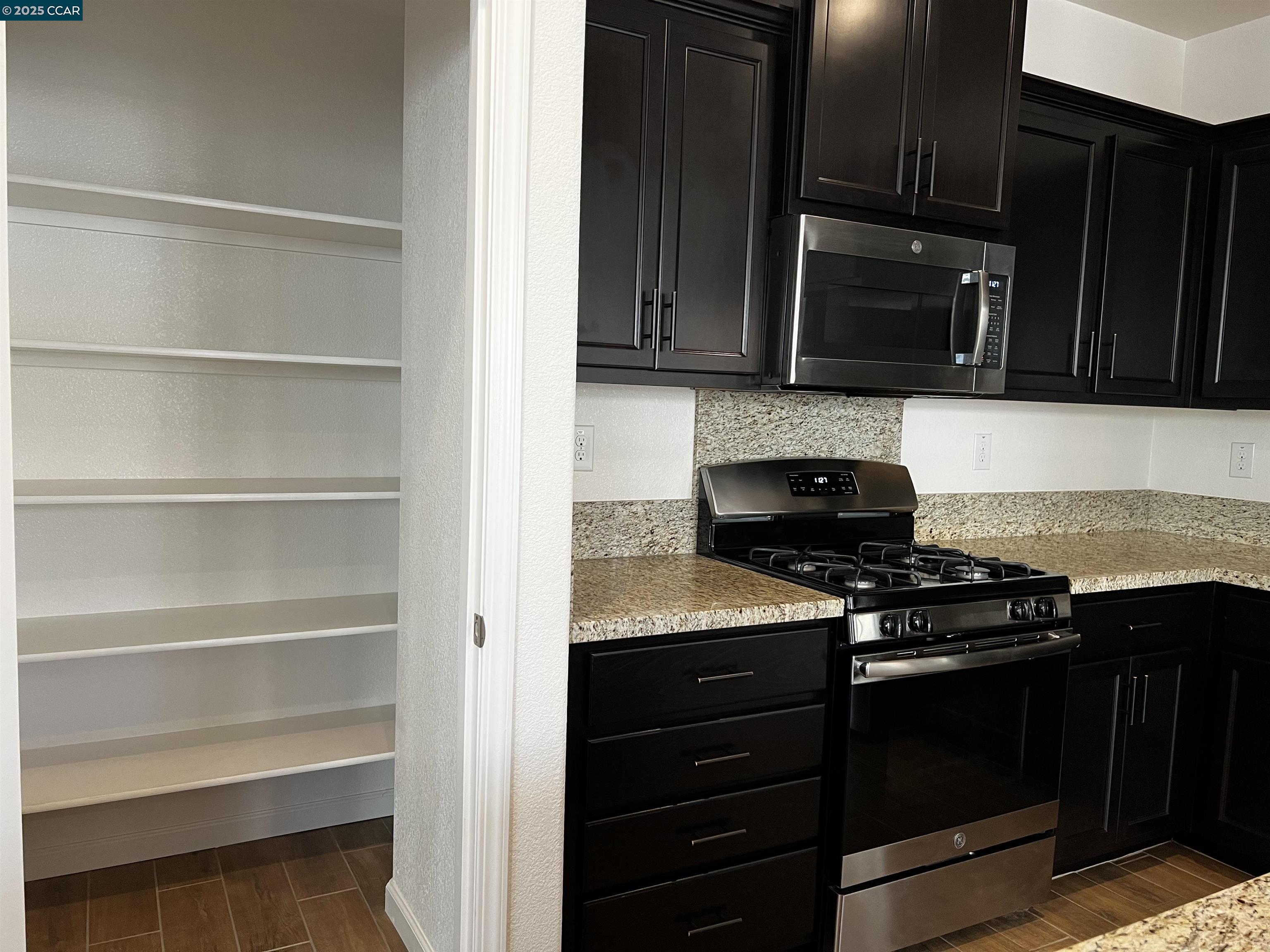 742 Iris Drive Vacaville, CA 95687 - Photo 3 of 23 a kitchen with wooden cabinets and black stove top oven