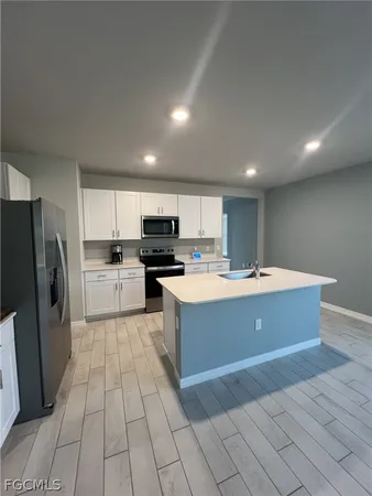 a large kitchen with stainless steel appliances granite countertop a large counter top a stove and a refrigerator