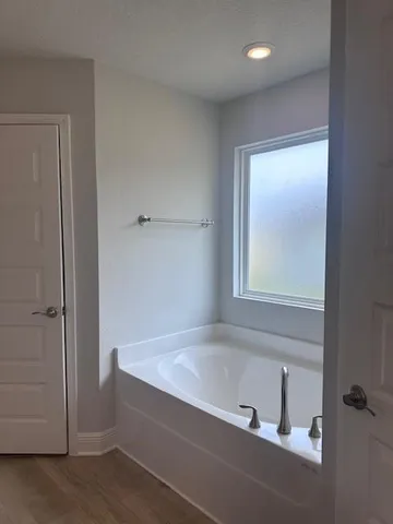 a bathroom with a bathtub and a window