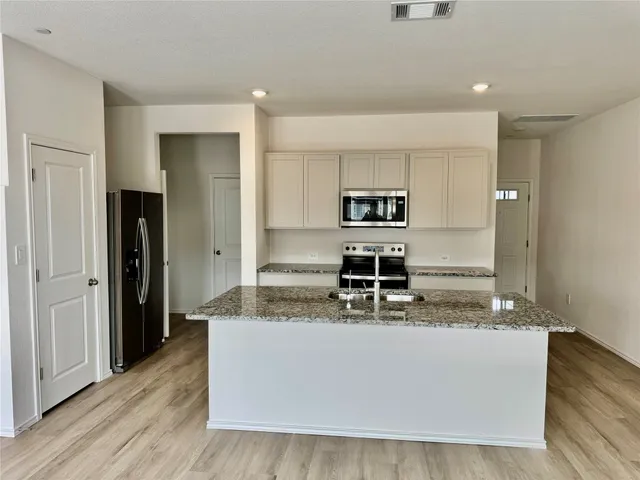 a large kitchen with kitchen island a sink stainless steel appliances and cabinets