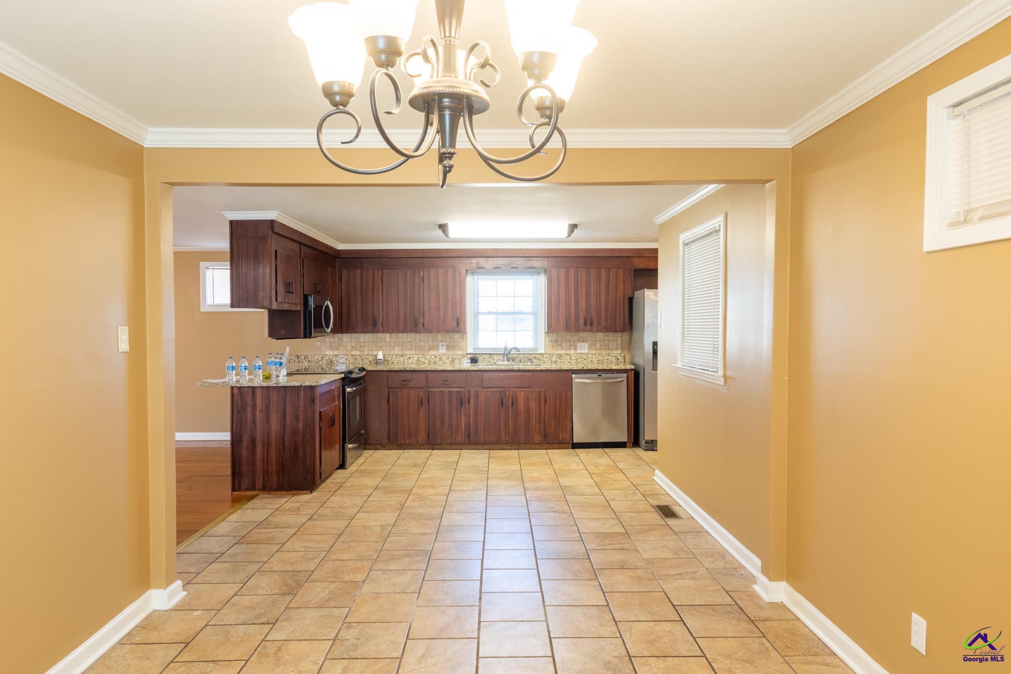 3491 Sandy Circle Macon, GA 31216 - Photo 10 of 47 a large kitchen with stainless steel appliances granite countertop a sink cabinets a stove and a window