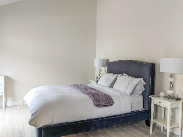 a large bed sitting in a bedroom and a table