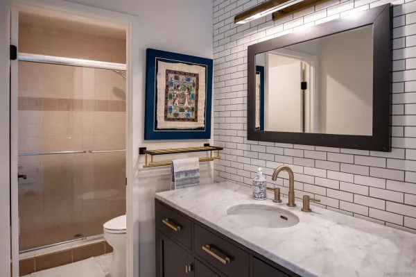 a bathroom with a granite countertop sink toilet and shower