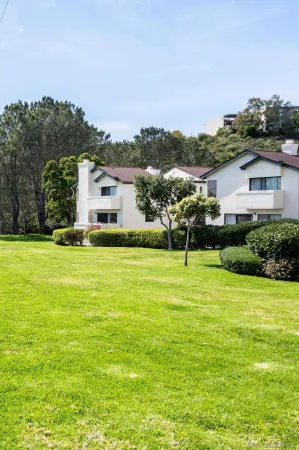 a front view of a house with a yard and trees