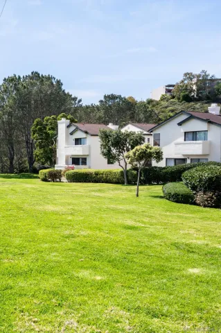 a front view of a house with a yard and trees