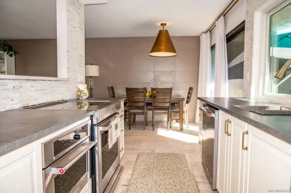a kitchen with stainless steel appliances granite countertop a sink and a stove