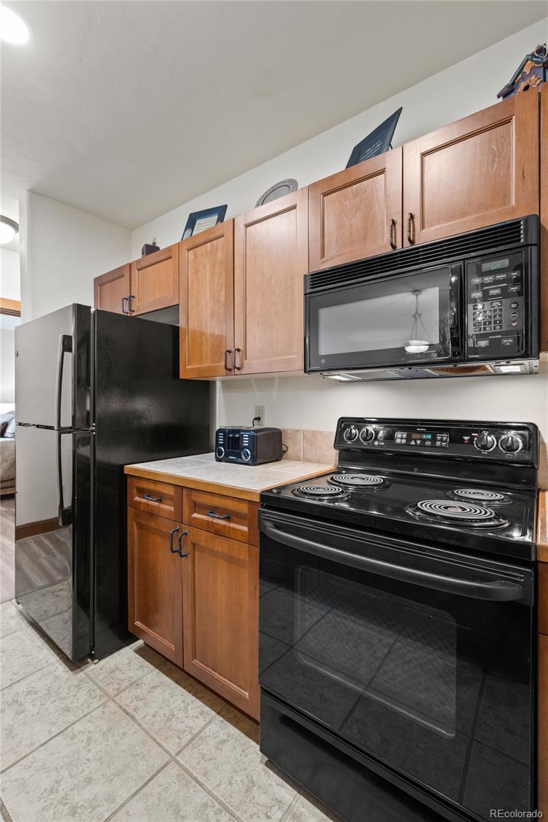 22787 Highway 6, Unit 209 Dillon, CO 80435 - Photo 47 of 49 a kitchen with stainless steel appliances granite countertop a stove microwave and refrigerator